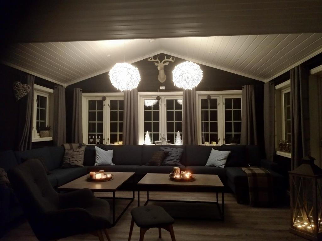 松达尔Sogndal ski- and mountain cabin的客厅配有蓝色的沙发和2张桌子