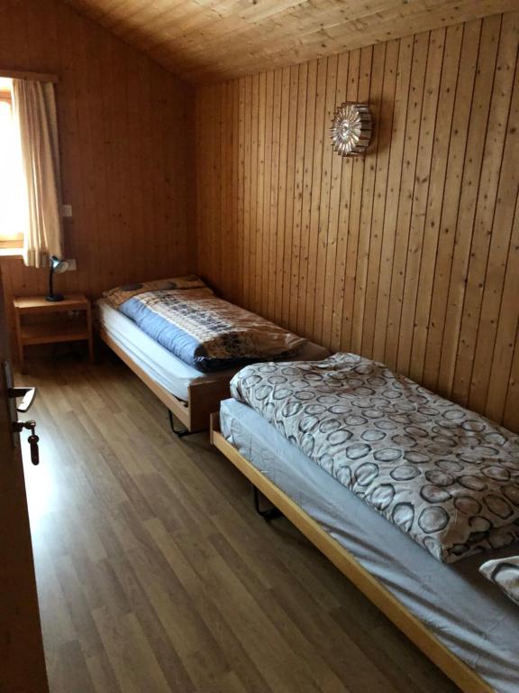马洛亚rest bellavista的木墙客房的两张床