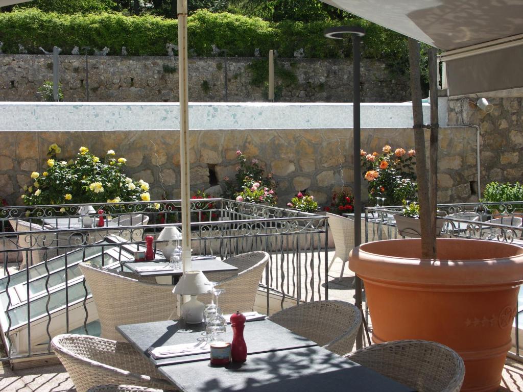 穆斯捷-圣玛丽伯恩奥伯格酒店的庭院里配有桌椅和遮阳伞