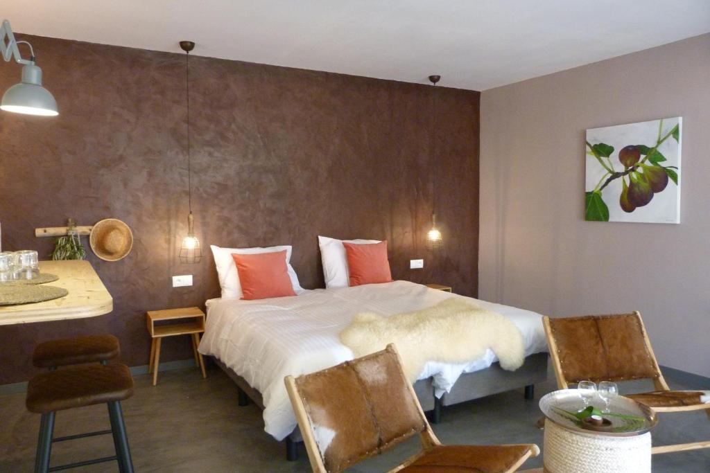 费雷拉杜阿连特茹Trendy and Luxe Bed & Breakfast的酒店客房带一张床、一张桌子和椅子