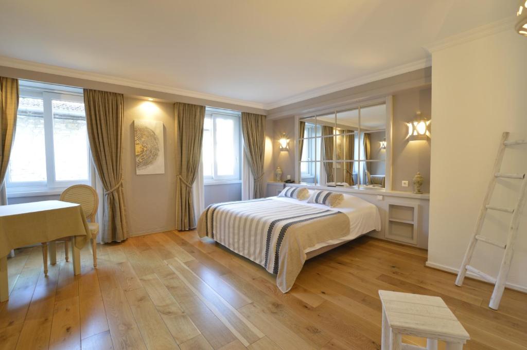 茹万维勒LE SOLEIL D'OR的一间卧室配有一张床、一张书桌和一面镜子