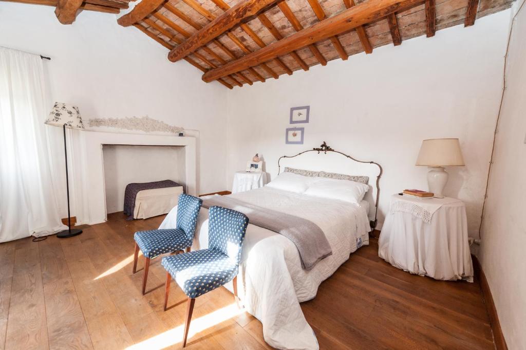 TavoletoLe Bumbarelle的一间白色卧室,配有一张床和两把椅子