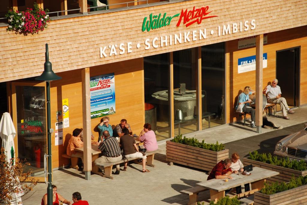 沃瑟姆阿尔伯格Wäldermetzge Hüttenzimmer und Wohnungen的一群人坐在餐厅外面