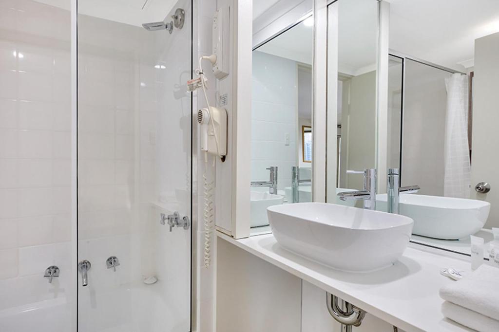 悉尼Renovated Stylish Studio的带水槽和淋浴的白色浴室