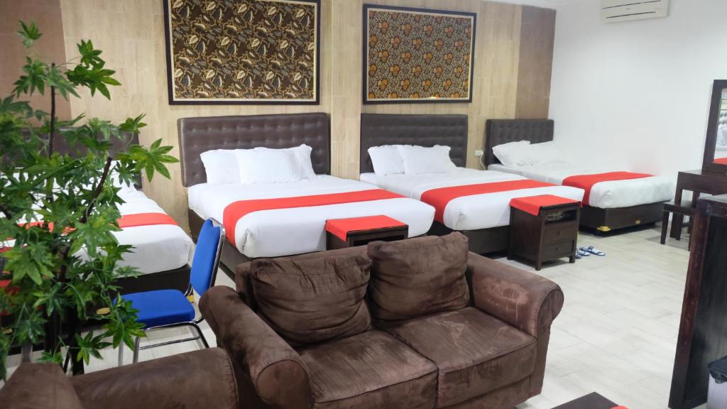 日惹日惹必玩之家旅馆的酒店客房,设有两张床和一张沙发
