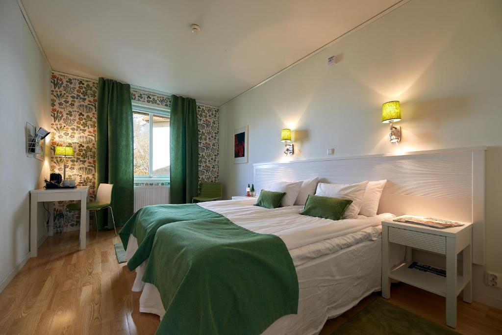 LyckeTofta Herrgård的卧室配有带绿色床单的大型白色床