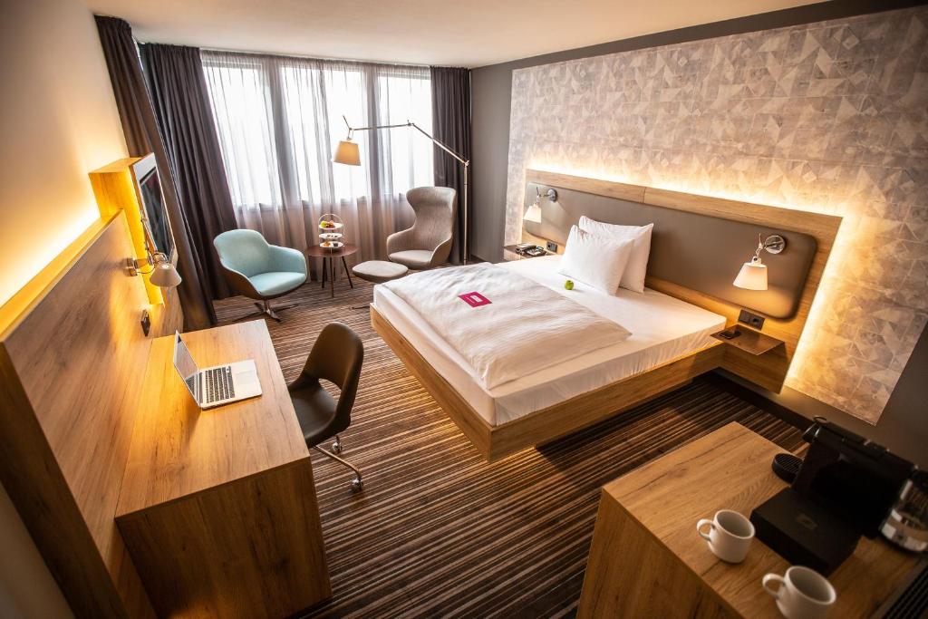 勒沃库森Leoso Hotel Leverkusen的配有一张床和一张书桌的酒店客房