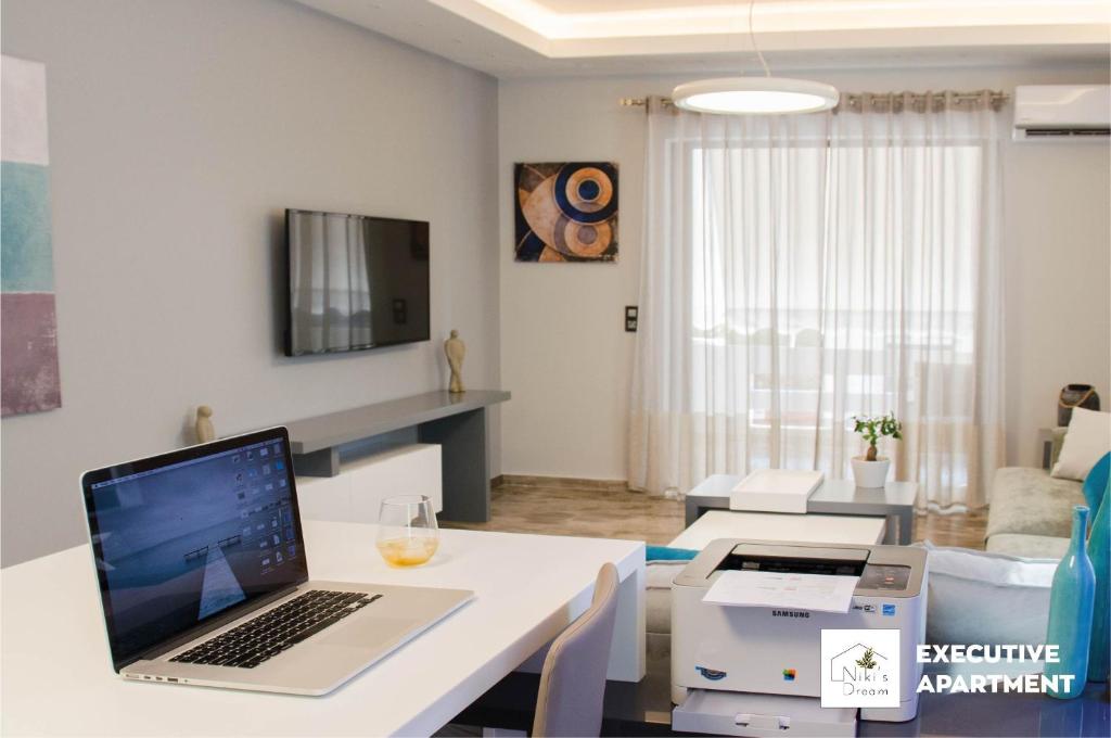 干尼亚Nikis Dream Luxury Apartments的客厅配有笔记本电脑,位于白色的桌子上