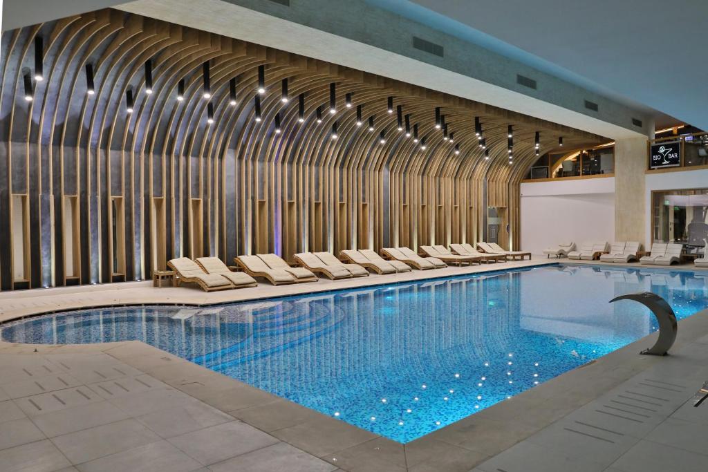 OveseluForest Retreat&Spa的大楼内带躺椅的大型游泳池