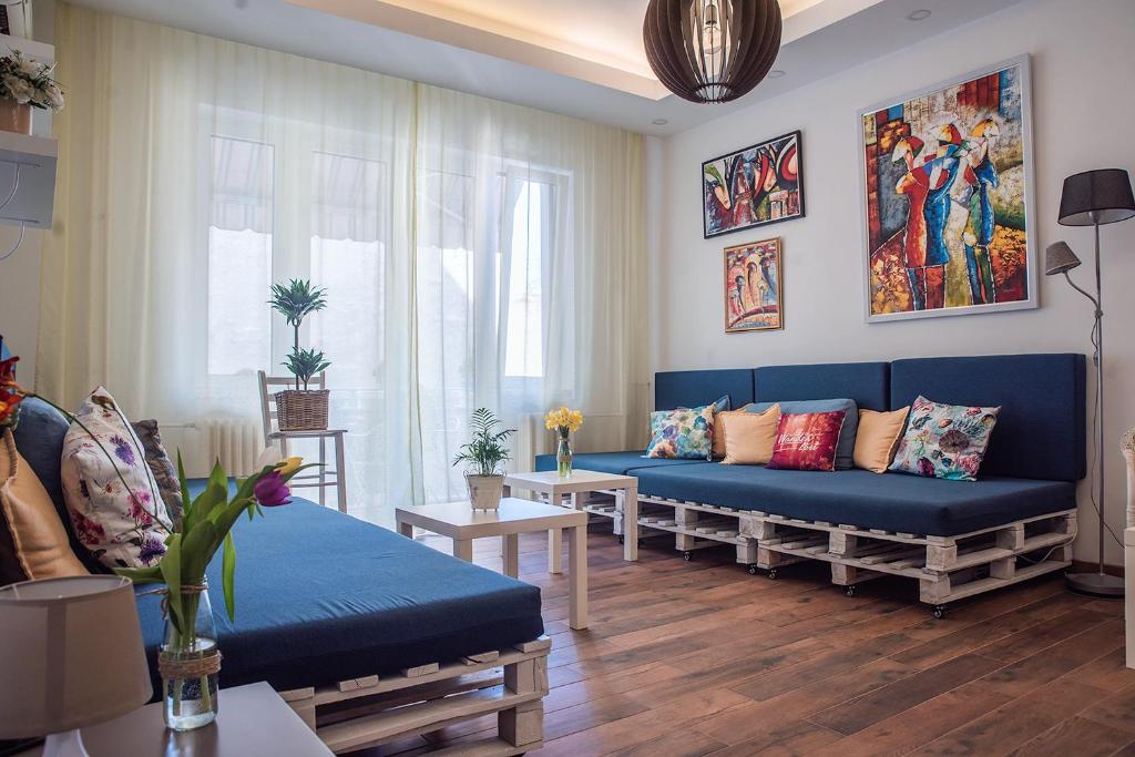 贝尔格莱德比昂咖人啊扎卡旅馆的客厅配有蓝色的沙发和桌子