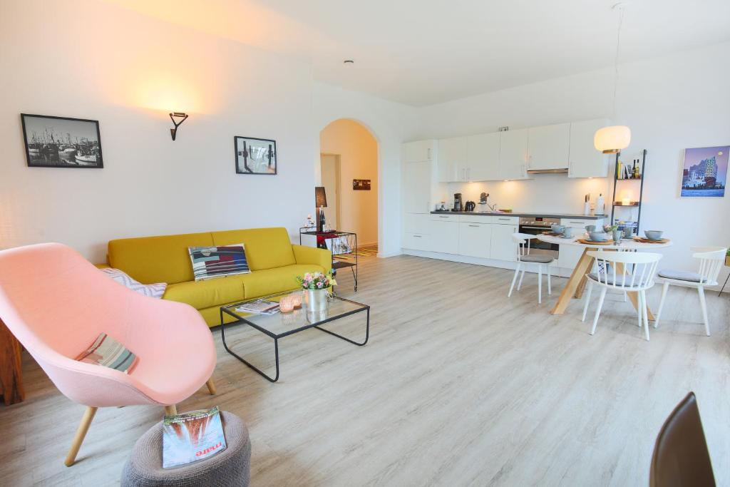 费马恩Appartements Villa Schwanenteich的一间带黄色沙发的客厅和一间厨房