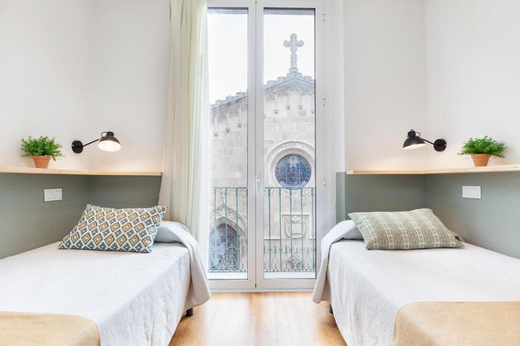 巴塞罗那费南多旅馆的带窗户的客房内的两张床