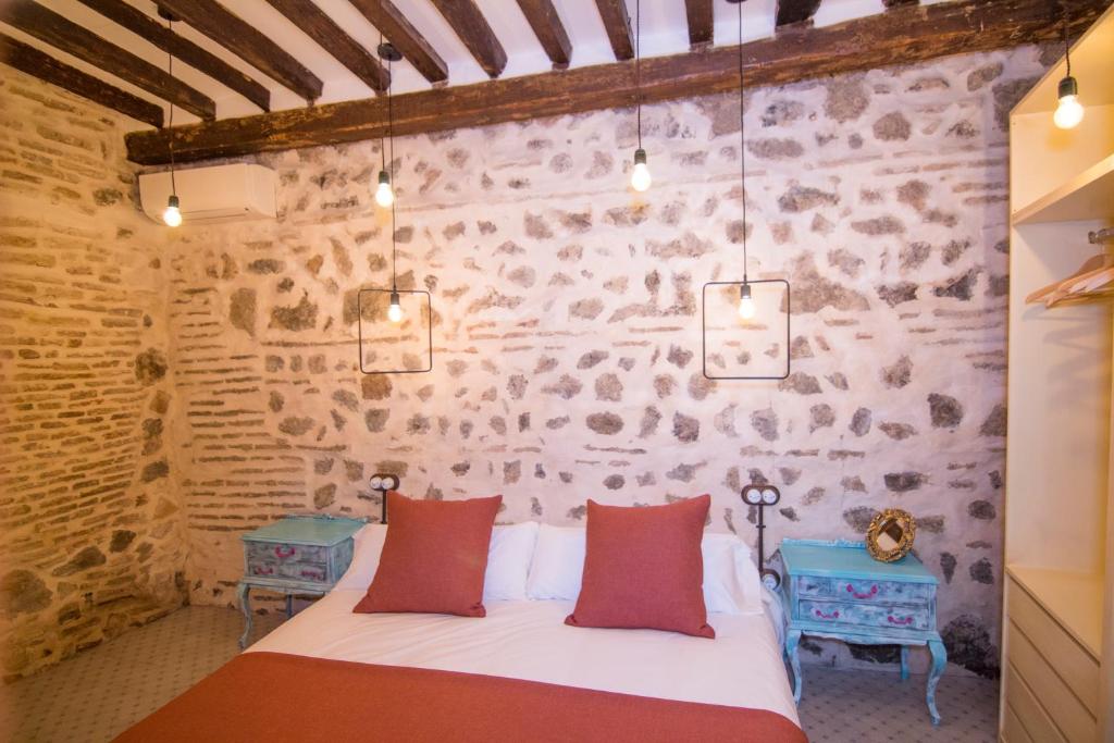 托莱多La Casa del Barquero的卧室配有一张石墙床