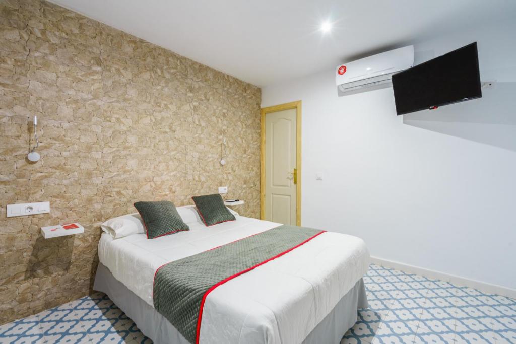 巴尔巴特Pensión Riad Mediterraneo的卧室配有一张大床,墙上配有电视