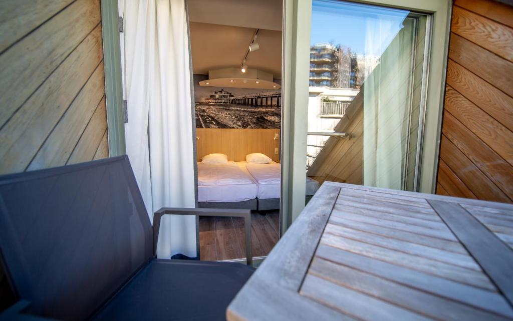 布兰肯贝赫Hotel Paradisio by WP Hotels的客房设有带一张床和一张桌子的阳台。