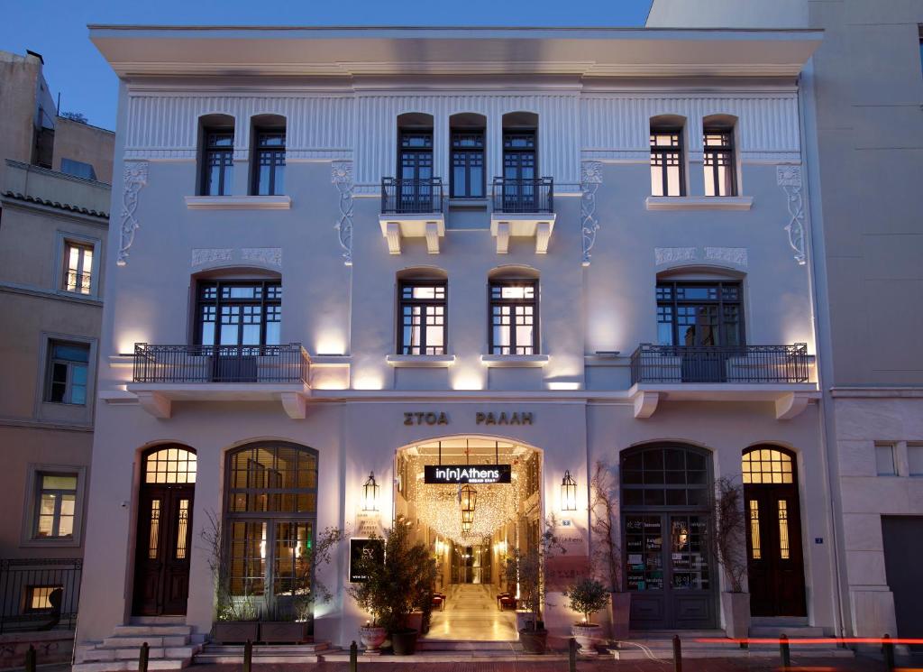 雅典雅典酒店的一座白色的大建筑,有灯光门廊