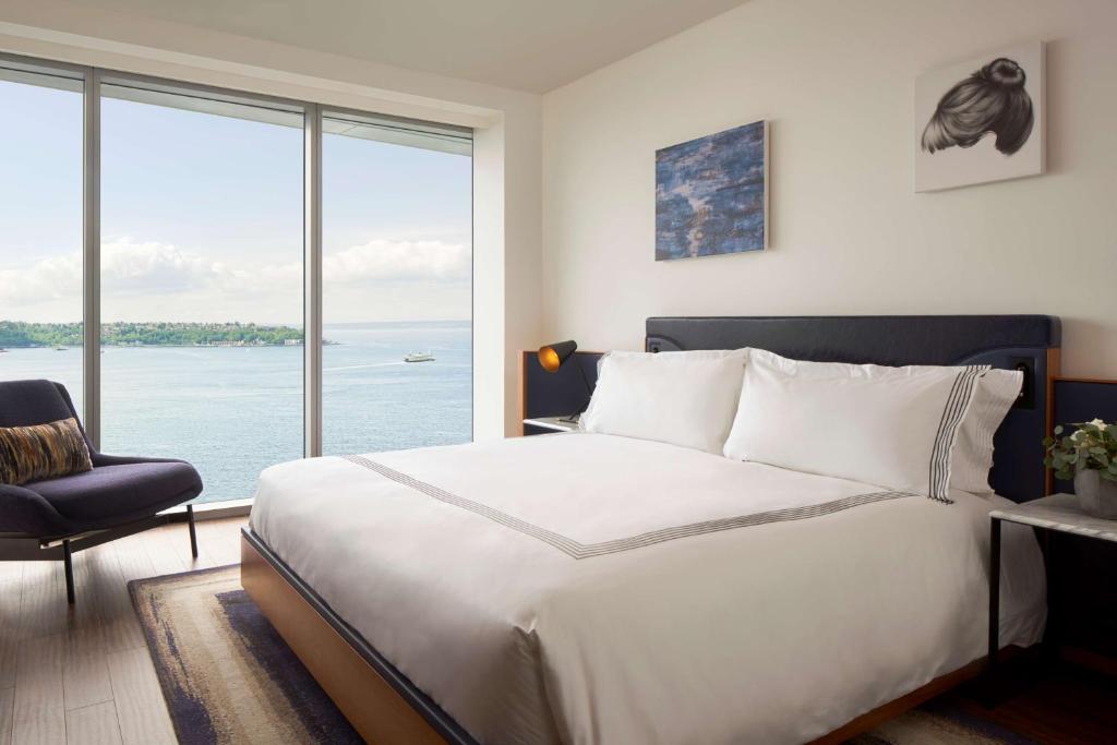 西雅图Thompson Seattle, by Hyatt的一间卧室设有一张大床和一个大窗户