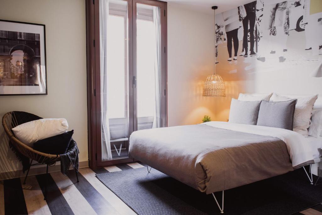 马德里room Select Sol的一间卧室配有一张大床和一把椅子