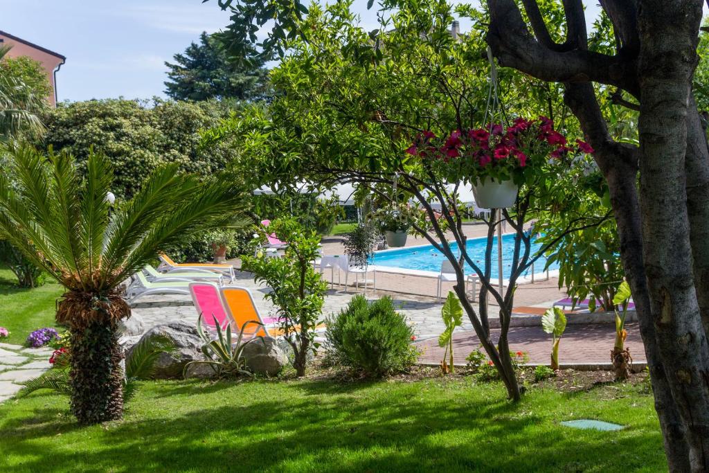 洛阿诺Le Villette di Villa Paola的一个带游泳池的花园和一个种有植物的庭院