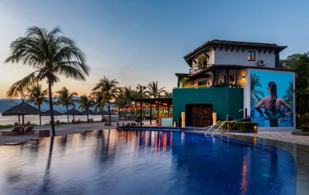 锡瓦塔塔内霍Thompson Zihuatanejo, A Beach Resort, by Hyatt的大楼前设有游泳池的酒店