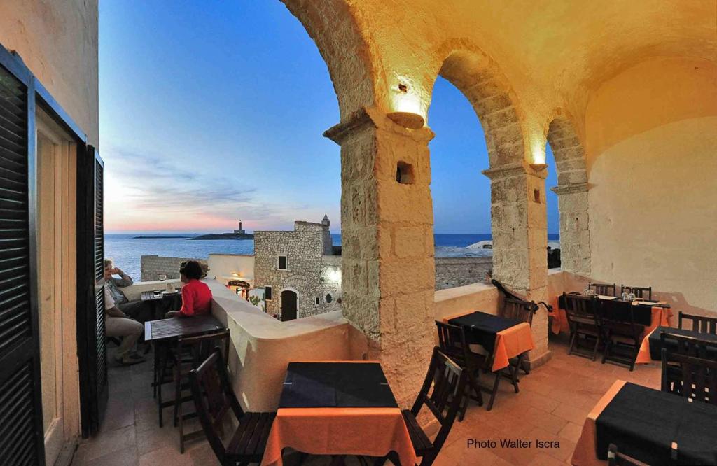 维耶斯泰Rocca Sul Mare Hotel的坐在阳台上的桌子上,欣赏海景的人