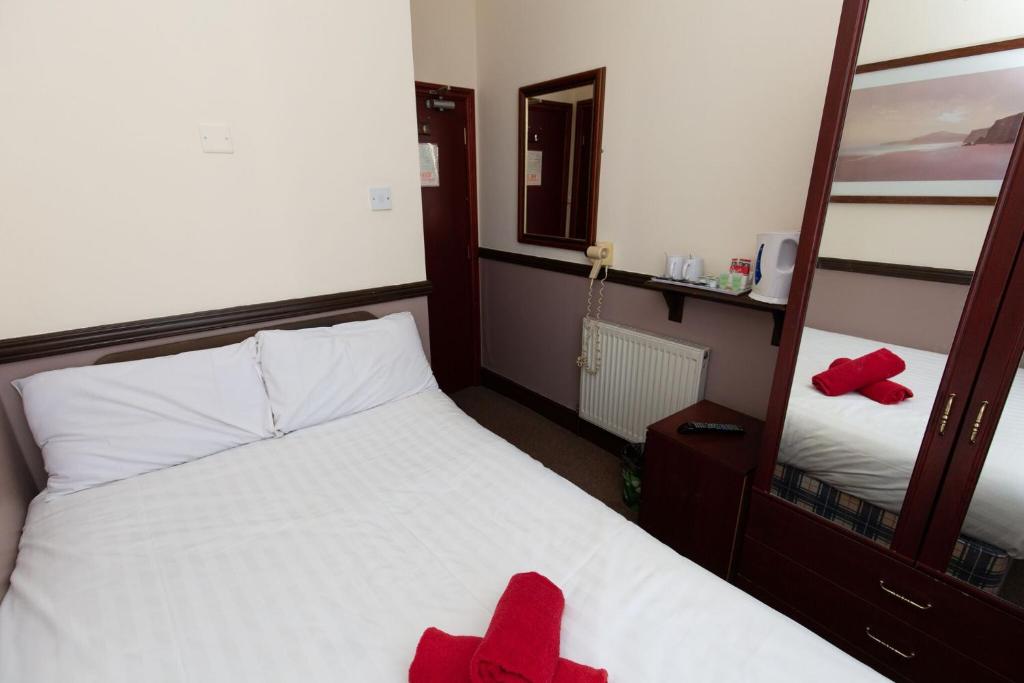 布莱克浦The Riviera Hotel的一间卧室配有一张带红色毛巾的床