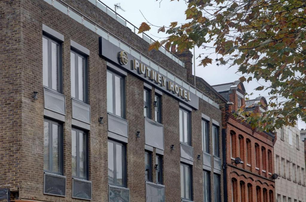 伦敦Putney Hotel; BW Signature Collection的砖砌的建筑,旁边标有标志