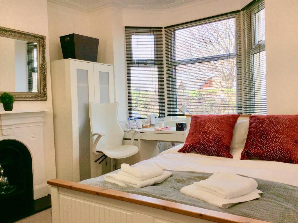 迪德科特Station House的一间卧室配有一张带红色枕头的床和一张书桌