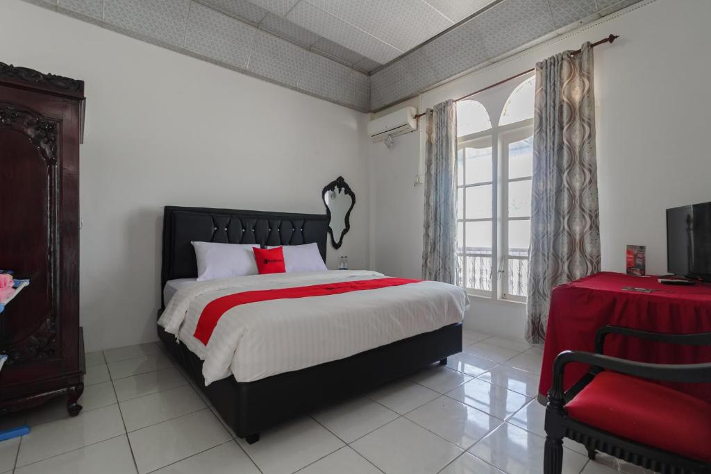 巴东RedDoorz Syariah near Universitas Negeri Padang的一间卧室设有一张大床和一个窗户。