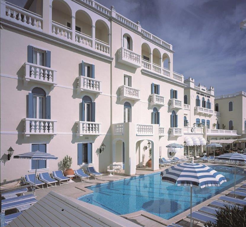 利多迪耶索罗Casa Bianca Al Mare的一座白色的大建筑,前面设有一个游泳池