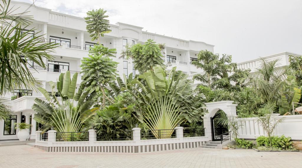 布琼布拉Hotel Kangaroo Bujumbura的前面有植物的白色建筑