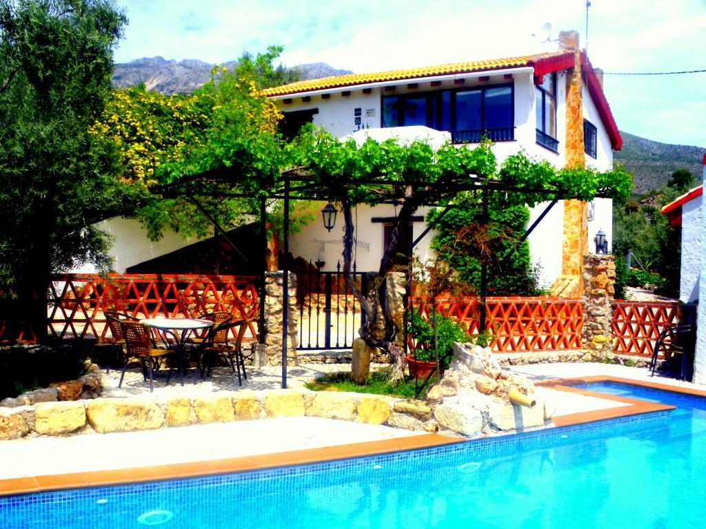 HuelmaAlojamiento rural El Agüelo的别墅前设有游泳池