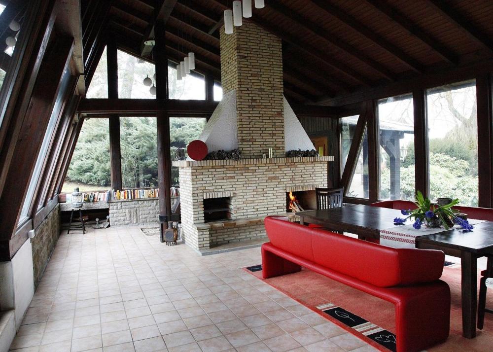 AmeckeInn66的客厅设有壁炉和红色沙发。