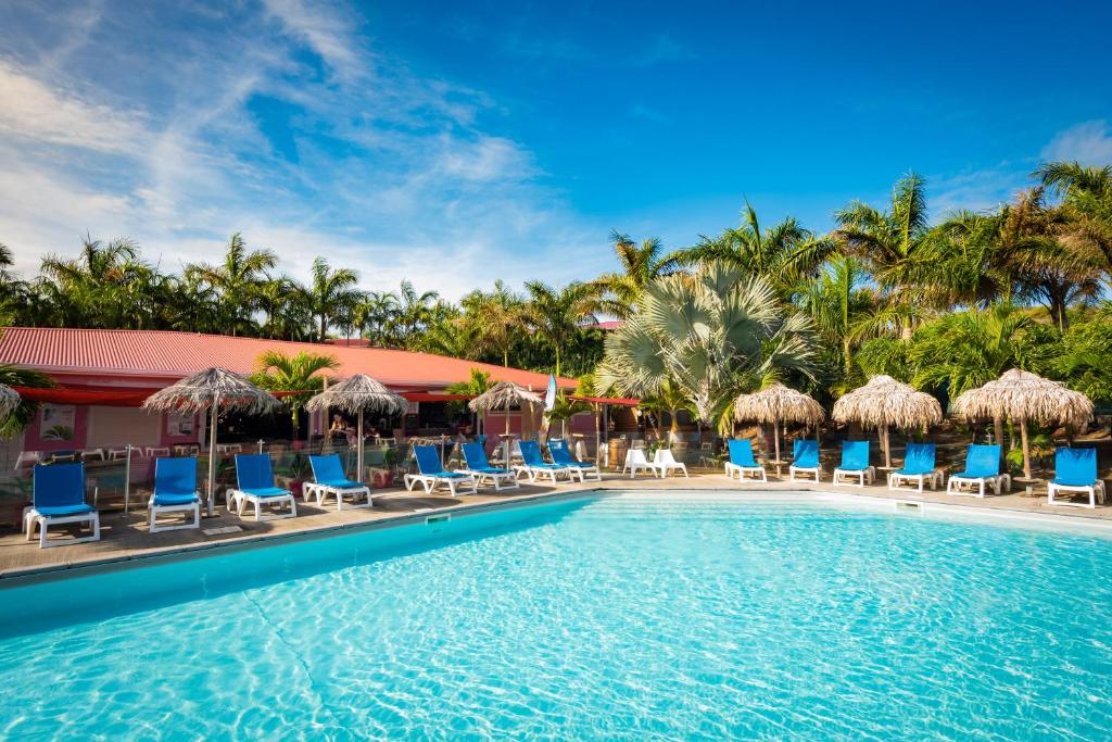 勒沃克兰乐村德拉蓬德度假村的度假酒店的游泳池配有椅子和遮阳伞