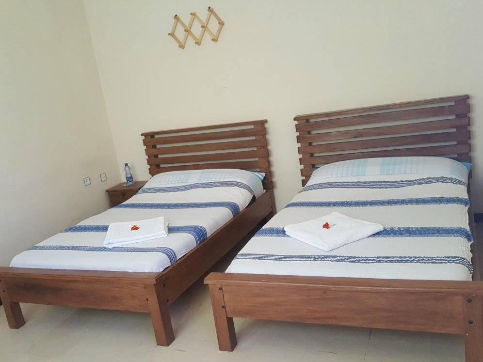 拉利贝拉Mini Lalibela Guest House的两张睡床彼此相邻,位于一个房间里