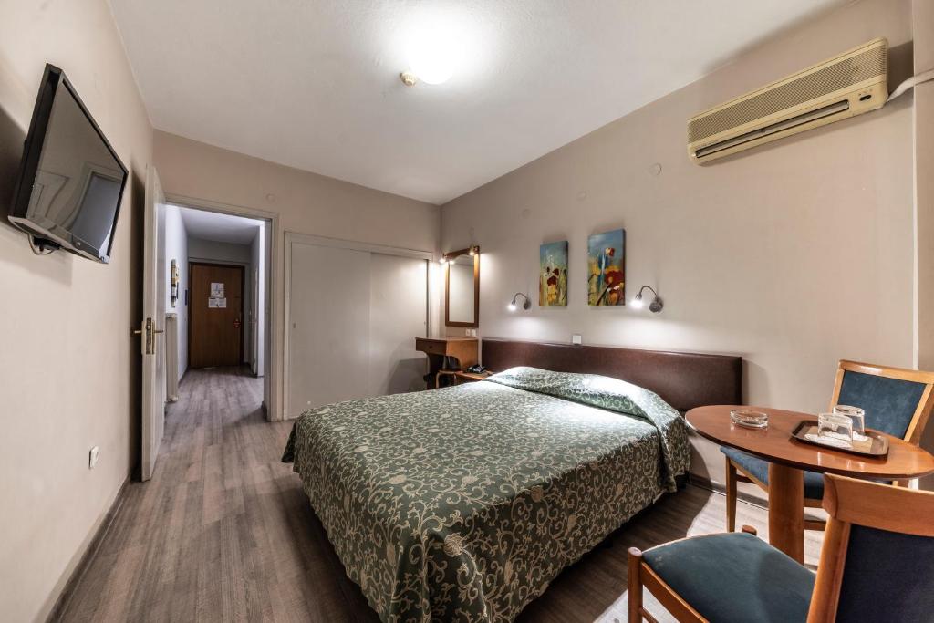 塞萨洛尼基维尔吉纳酒店的酒店客房配有一张床铺和一张桌子。