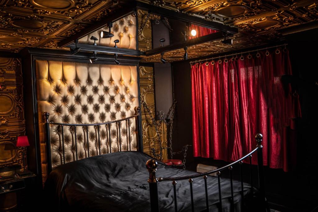 布莱顿霍夫Brighton Erotic Boudoir的一间卧室配有床和红色窗帘
