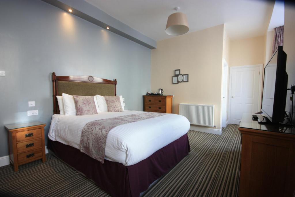 滕比斯特拉斯莫尔酒店的一间卧室配有一张大床和电视