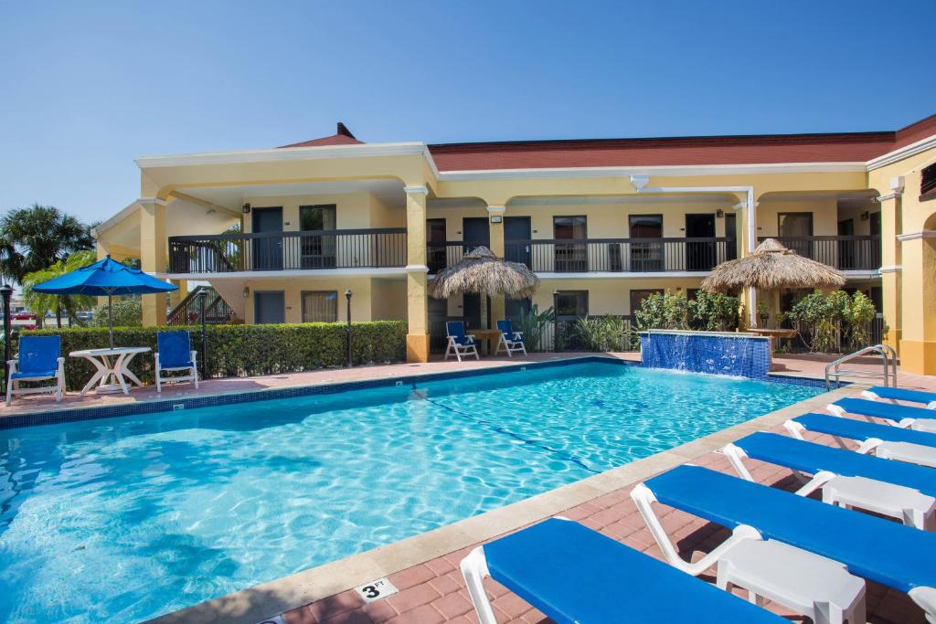 佛罗里达市佛罗里达州戴斯酒店 的酒店前的游泳池配有椅子和遮阳伞