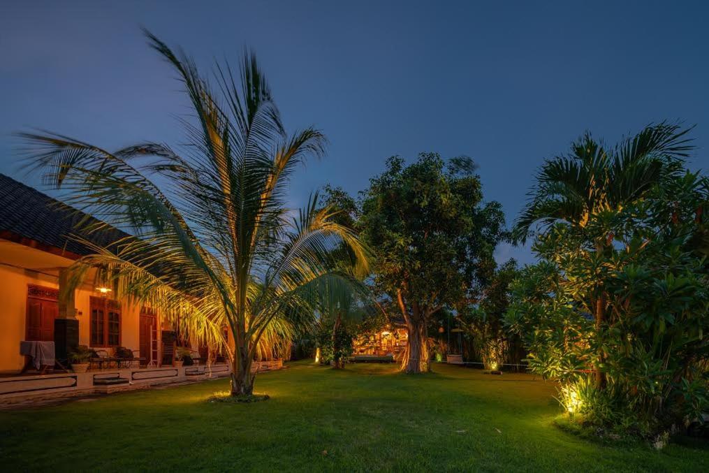 乌鲁瓦图巴厘岛寄宿旅馆的公园里棕榈树和灯光照亮,晚上