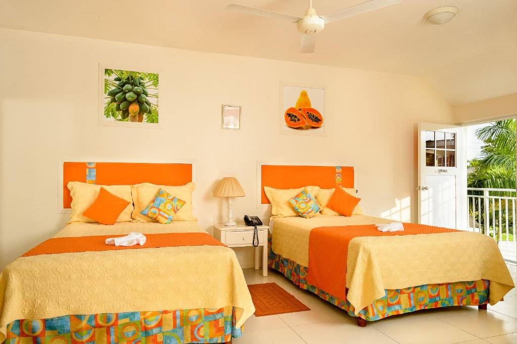 尼格瑞尔龙德尔度假村的橙黄色卧室内的两张床