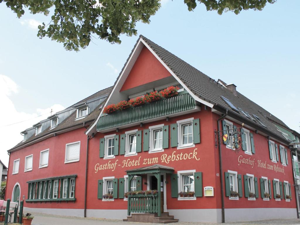 玛特丁恩Gasthof Hotel zum Rebstock的前方有鲜花的红色建筑