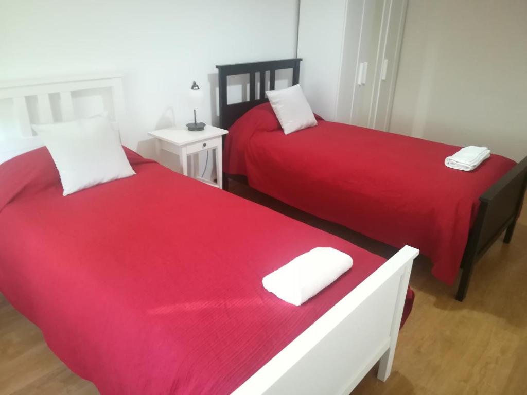 阿尔马达Casa do Pedro - Lisbon South Bay的红色床单的客房内的两张床