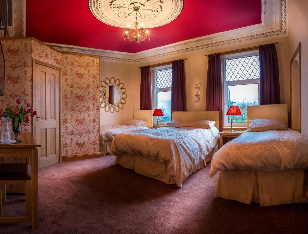 斯特兰拉尔湖景宾馆的一间卧室设有两张床和红色天花板
