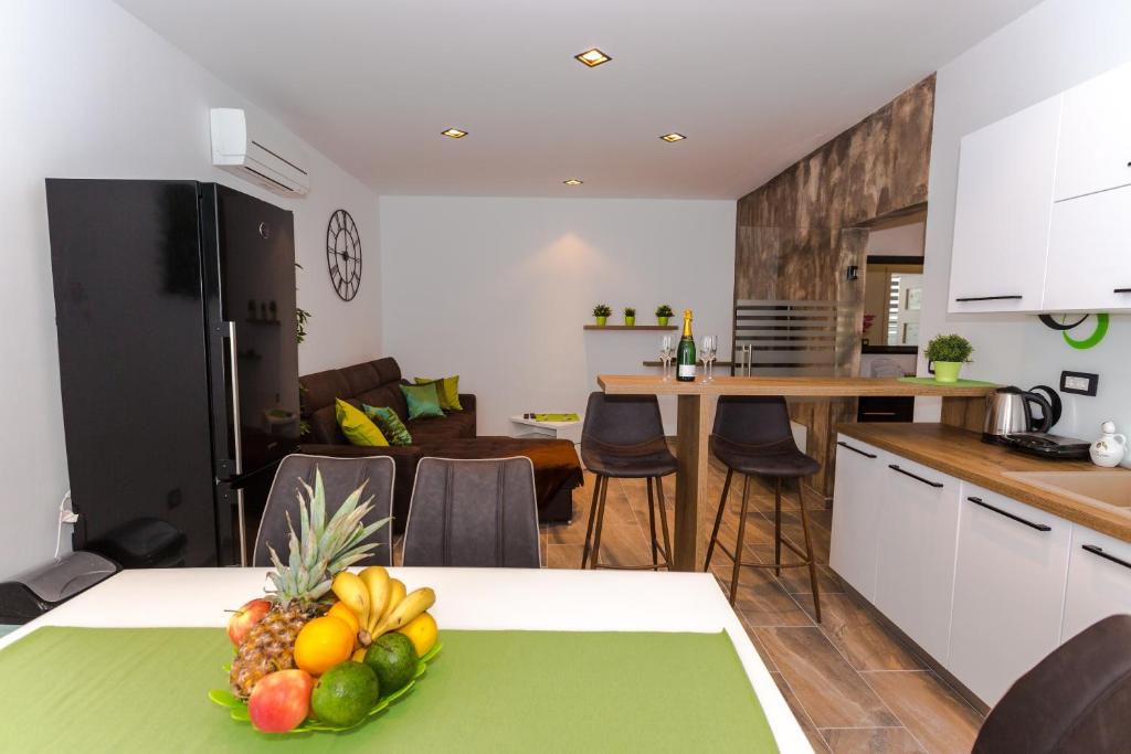 里耶卡Sensitive relax apartment的厨房配有一张桌子,上面放着一碗水果