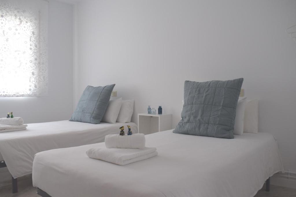 波尔托马林La Casa de Manuel的客房内的两张白色床和毛巾