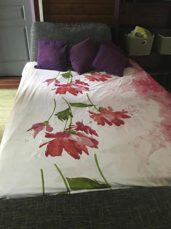 La RivièreLe Chalet dAZAE的一张带紫色枕头的红色鲜花床
