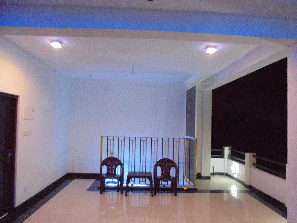 尼甘布JMF Hotel的客厅里设有两把椅子,配有电视
