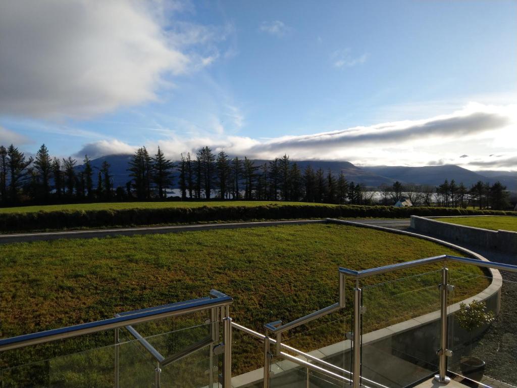 基拉尼Arbutus Lodge的楼梯通往一个以山为背景的草地