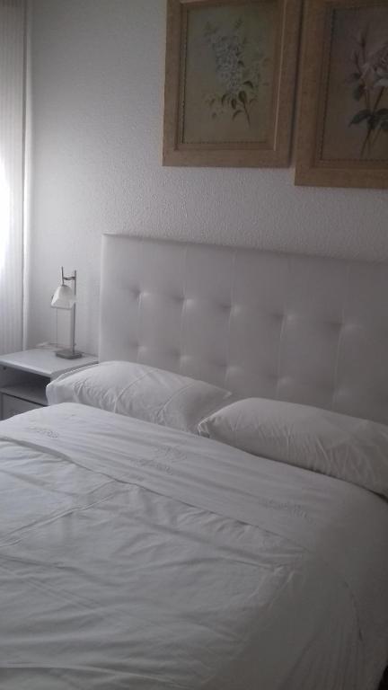 潘普洛纳潘普洛纳客房旅馆的一间卧室配有两张白色的床和一盏灯